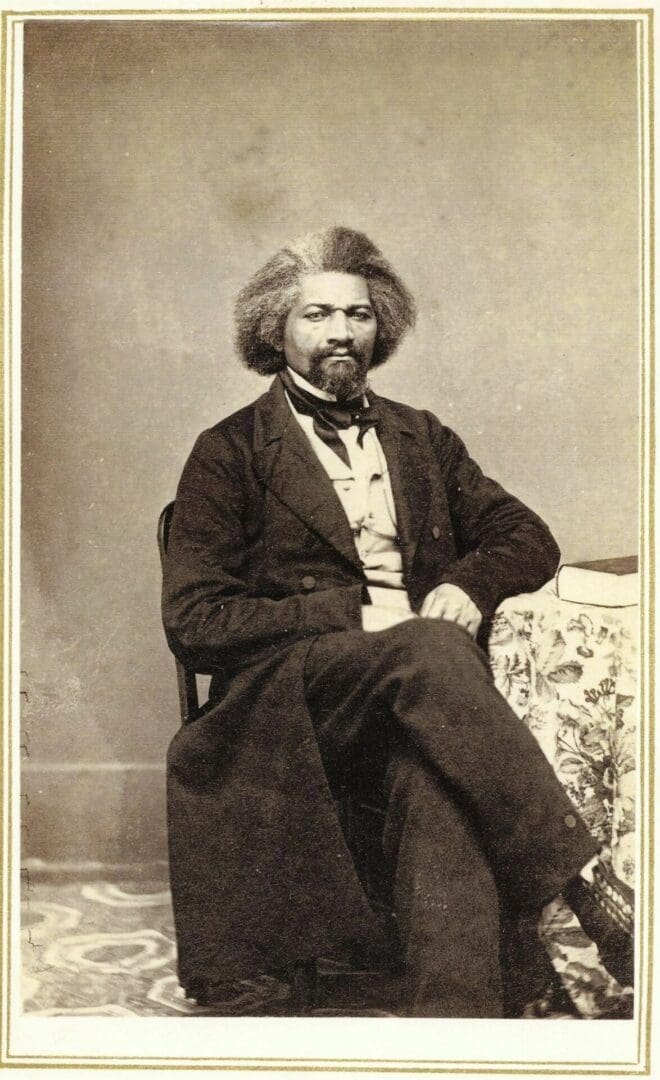 A man sitting in a chair wearing a suit and tie.